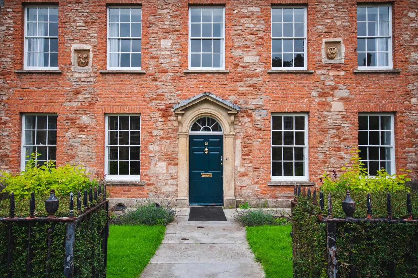 A red-brick Georgian house with a stone doorcase and a painted front door